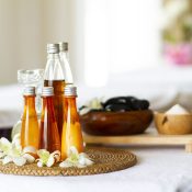 Spa accessories wellness setting with cosmetic bottles and salt with orchid, blurred massage stones in wooden bowl, spa concept, copy space